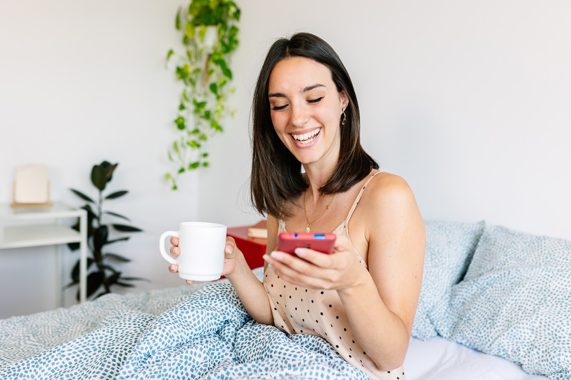 Young happy woman having fun watching social media content on phone app