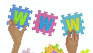 Hands forming word "www" with jigsaw puzzle pieces isolated